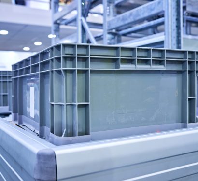 Side view of plastic crates at conveyor belt.