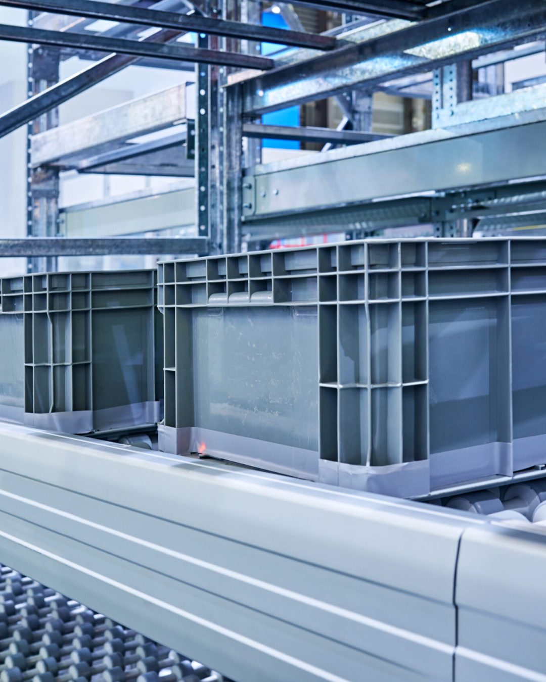 Side view of plastic crates at conveyor belt.